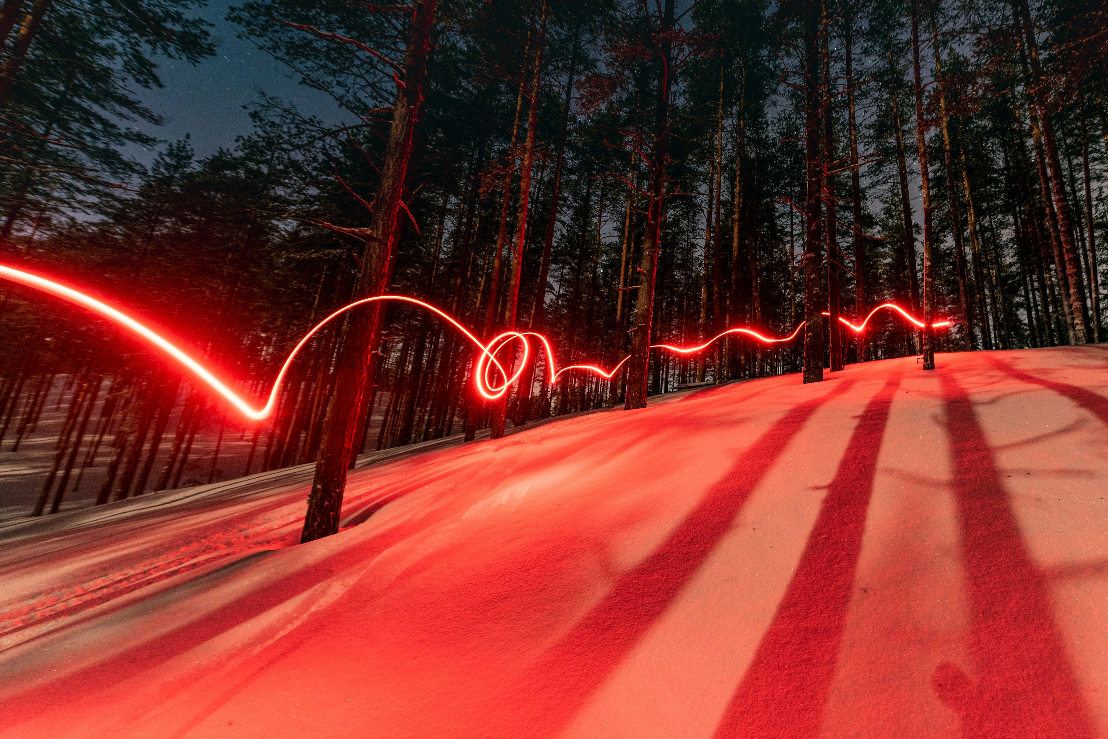 great photo recipe,how to photograph moonlight skiing; a long exposure photo of a red light in the woods