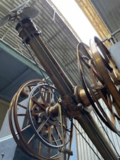A skilled engineer inspecting the intricate mechanisms of an industrial hangar door system.