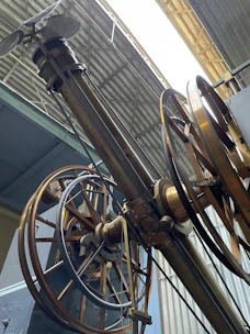 Heavy machinery parts connected with robust metal hinges in an industrial setting.