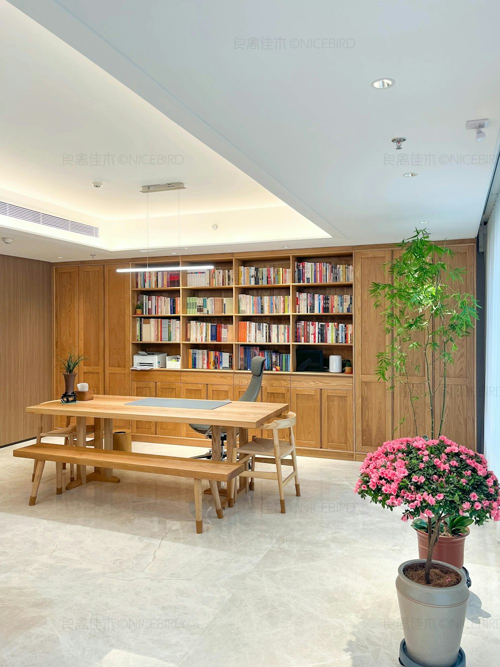 a table and benches in a room with a bookcase