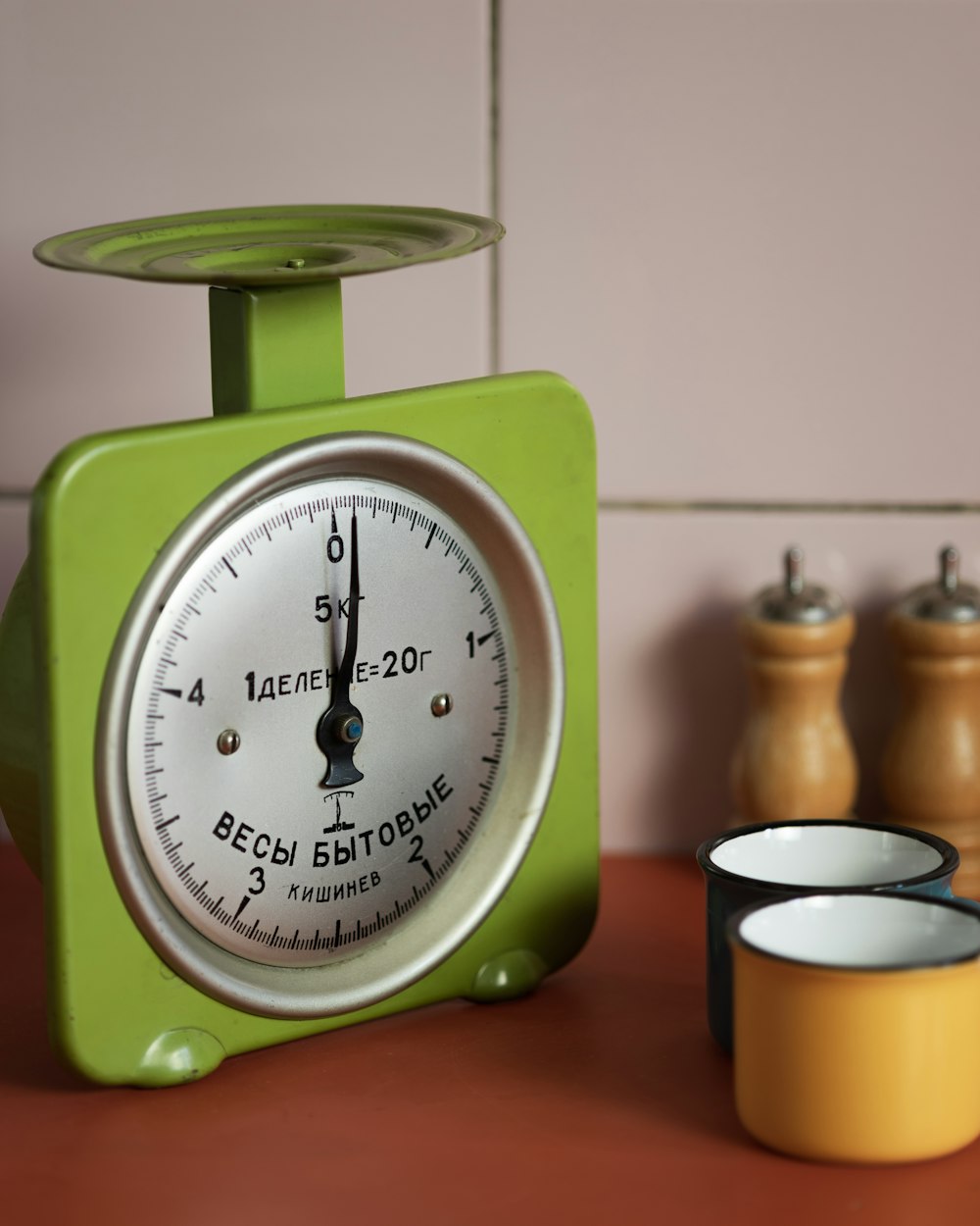 a green clock sitting on top of a wooden table