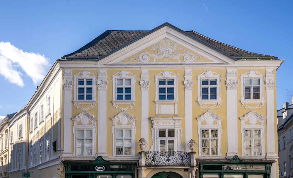 a yellow building with white trim and windows