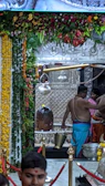Priests performing a sacred pooja with traditional brass vessels and flowers.