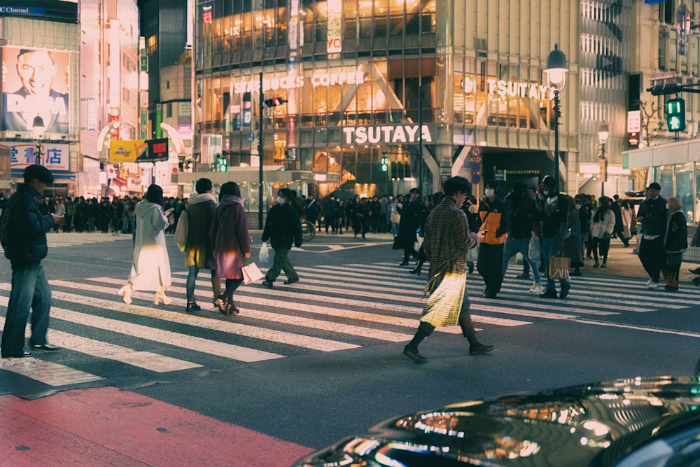 a group of people walking across a cross walk