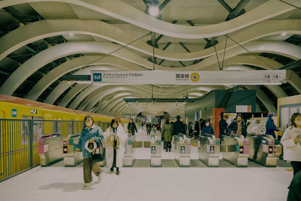 a group of people walking through a train station