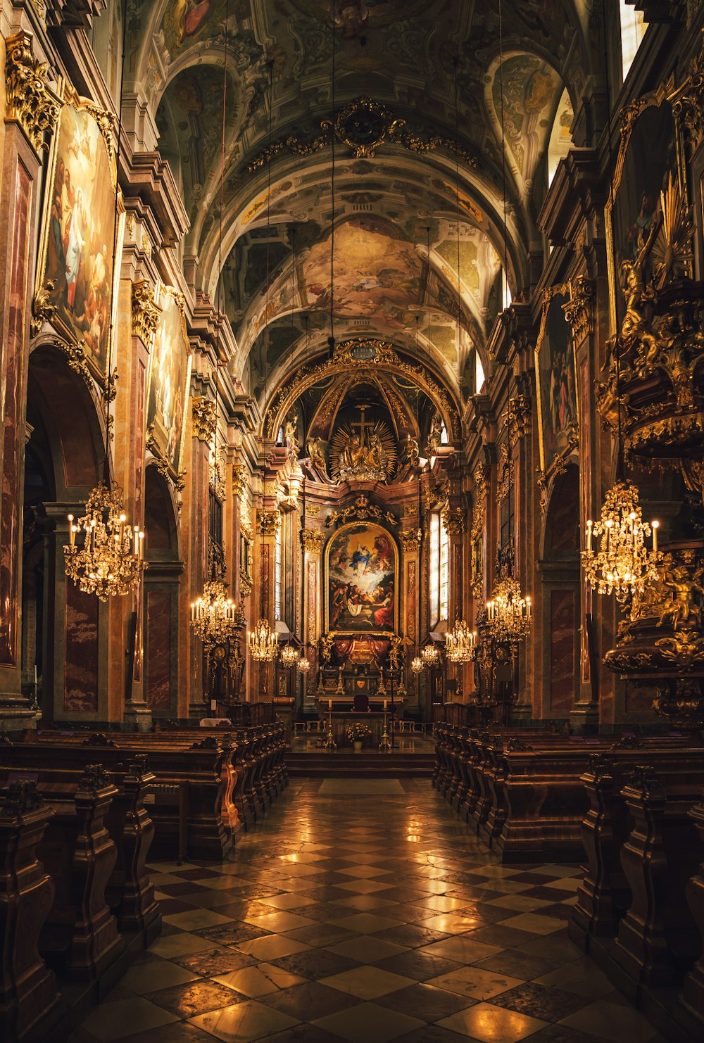 a church with a lot of pews and chandeliers