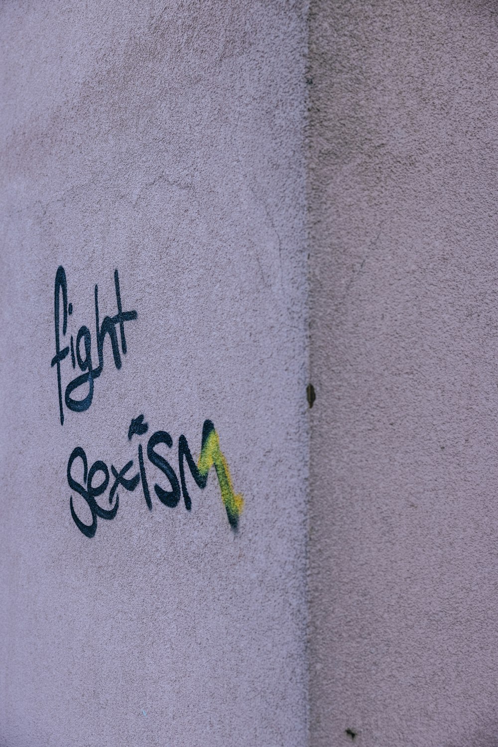 Graffiti an der Seite eines Gebäudes, das sagt, Sexismus zu bekämpfen
