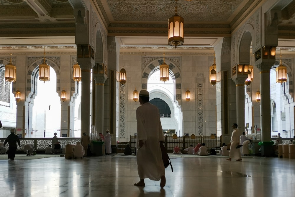 a man in a white robe is walking through a building