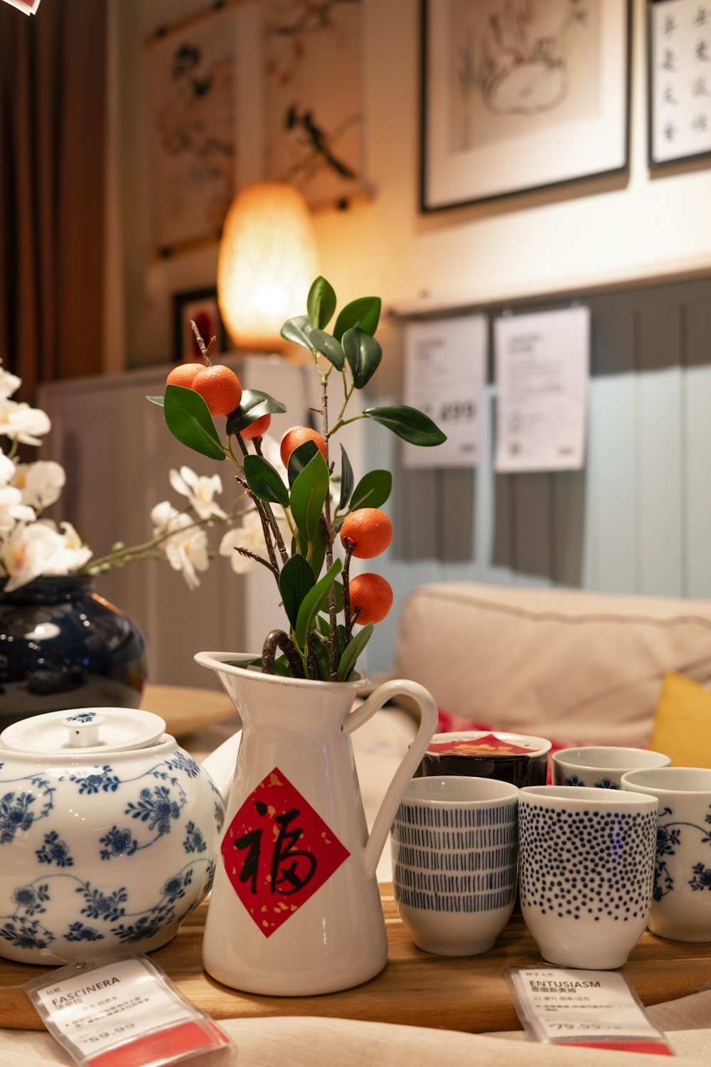 a table topped with cups and a vase filled with flowers