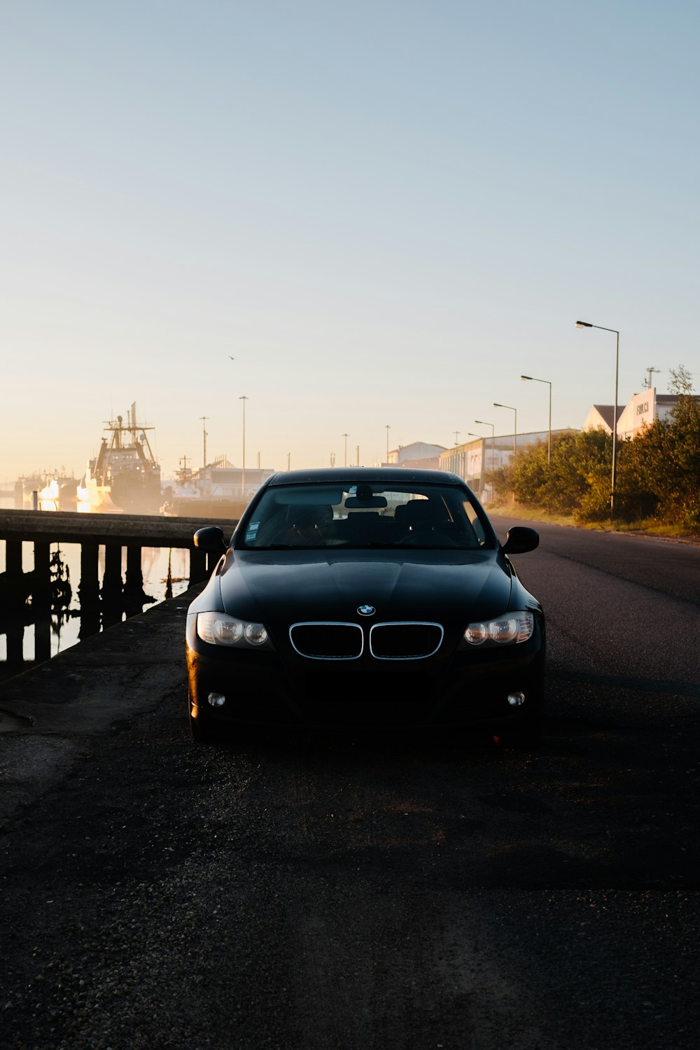 a car parked on the side of a road next to a body of water