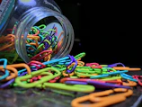 Close-up of colorful shaped paper clips arranged neatly on a light gray surface.