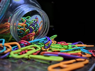 Close-up of paper clips and pins scattered artistically on a white surface.