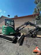 Technician installing GPS tracker on a stationary construction machine