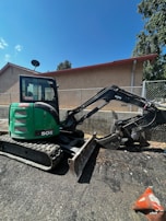 A 309cr mini excavator parked beside a freshly dug trench at a construction site.