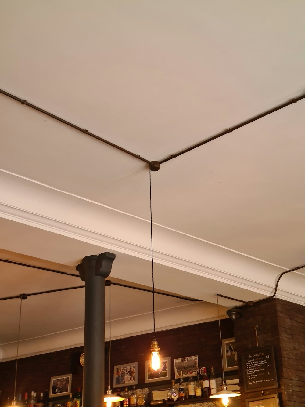 the ceiling of a restaurant with lights hanging from the ceiling