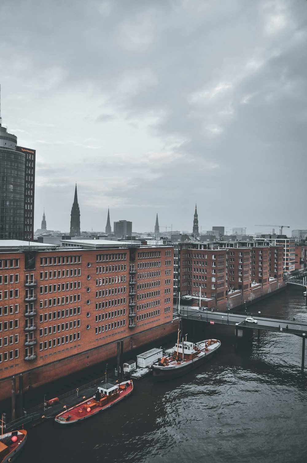 two boats are docked near a large brick building