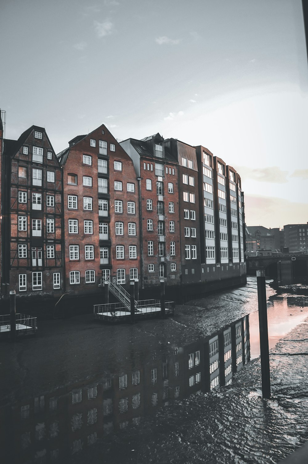 a row of red brick buildings next to a body of water