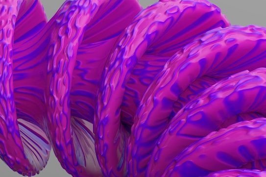 An abstract, artistically rendered spiral structure with a smooth, twisted form and a textured surface. The spiral features vibrant, iridescent colors predominantly in shades of pink and purple, with intricate, wave-like patterns. The background is a muted gray, providing a stark contrast to the vivid hues of the spiral.