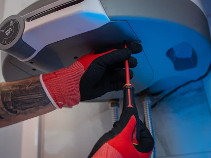 Close-up of a technician’s hands carefully inspecting a refrigerator’s cooling system.