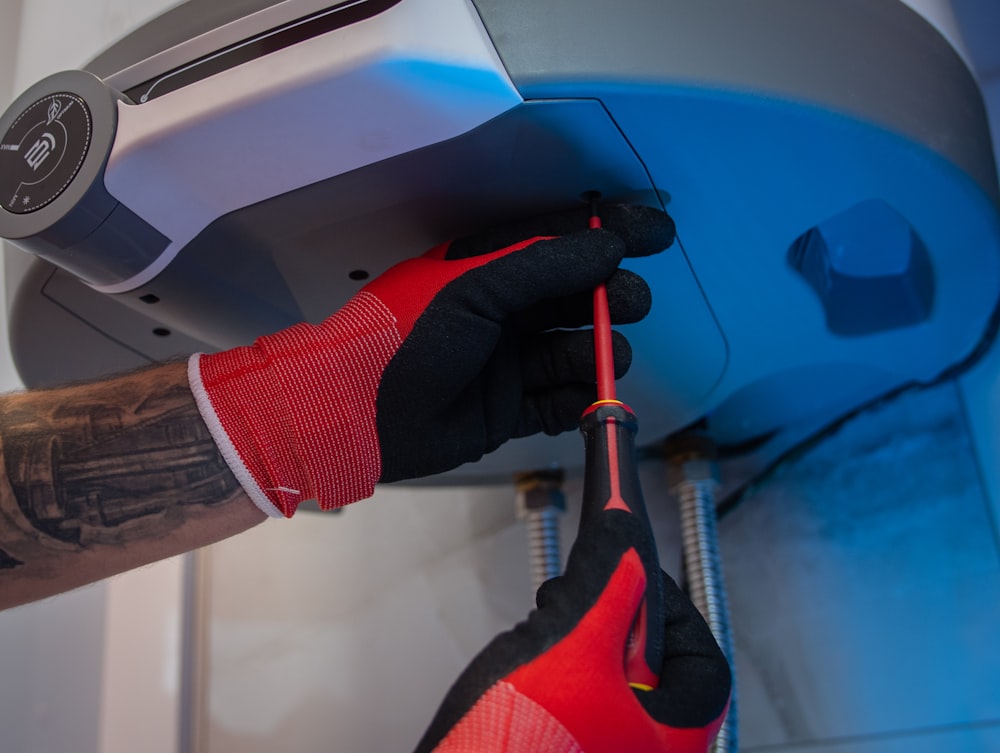 a man in red gloves working on a machine