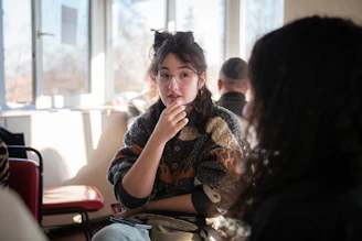 A mentor and a young person sharing a thoughtful conversation in a cozy, sunlit room.