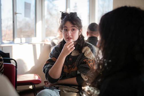 A mentor and a young person sharing a thoughtful conversation in a cozy, sunlit room.