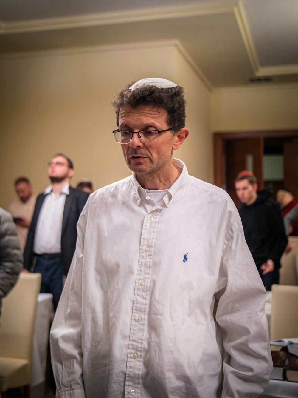 a man in a white shirt standing in front of a group of people