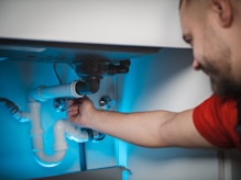 A skilled handyman repairing a kitchen faucet in a bright residential home.