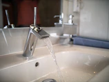 A sleek bathroom faucet with water flowing smoothly.