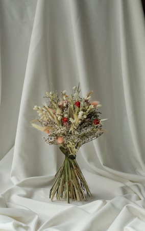 a bouquet of flowers sitting on top of a white cloth