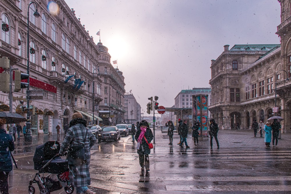 a group of people walking across a street in the rain