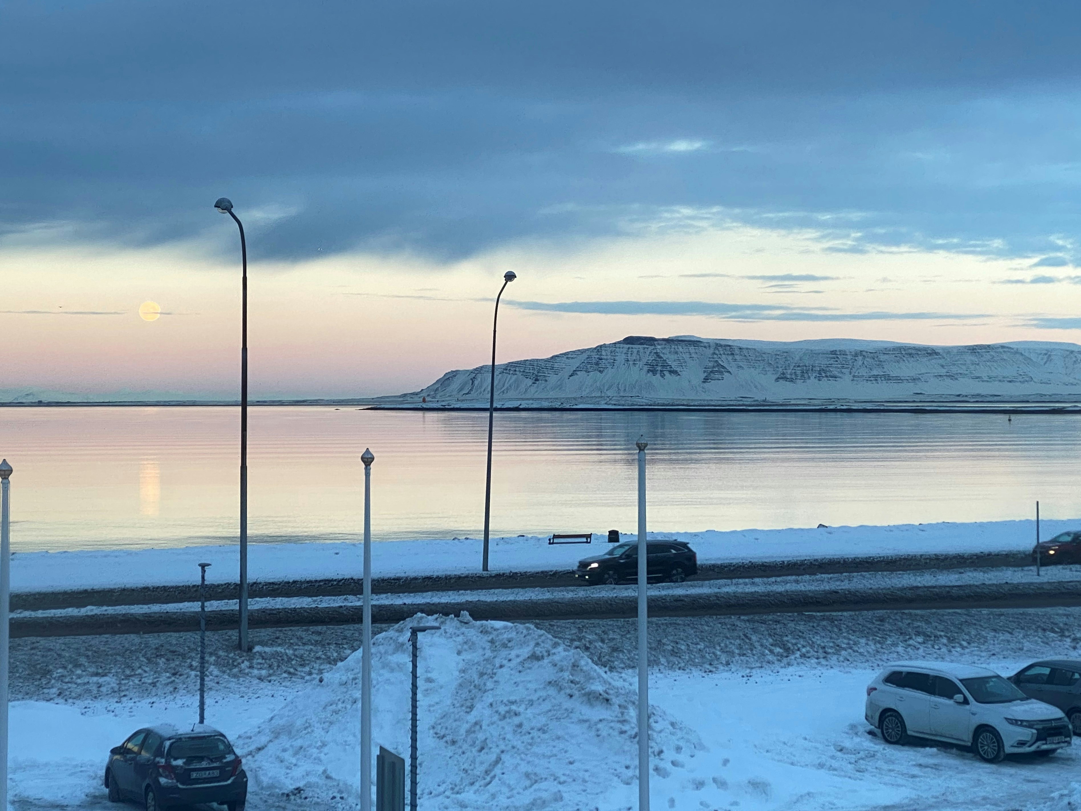 cars parked on the side of the road in the snow