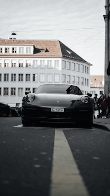 Low front angle shot of a black Ford Mustang with an aggressive front splitter in an urban setting.
