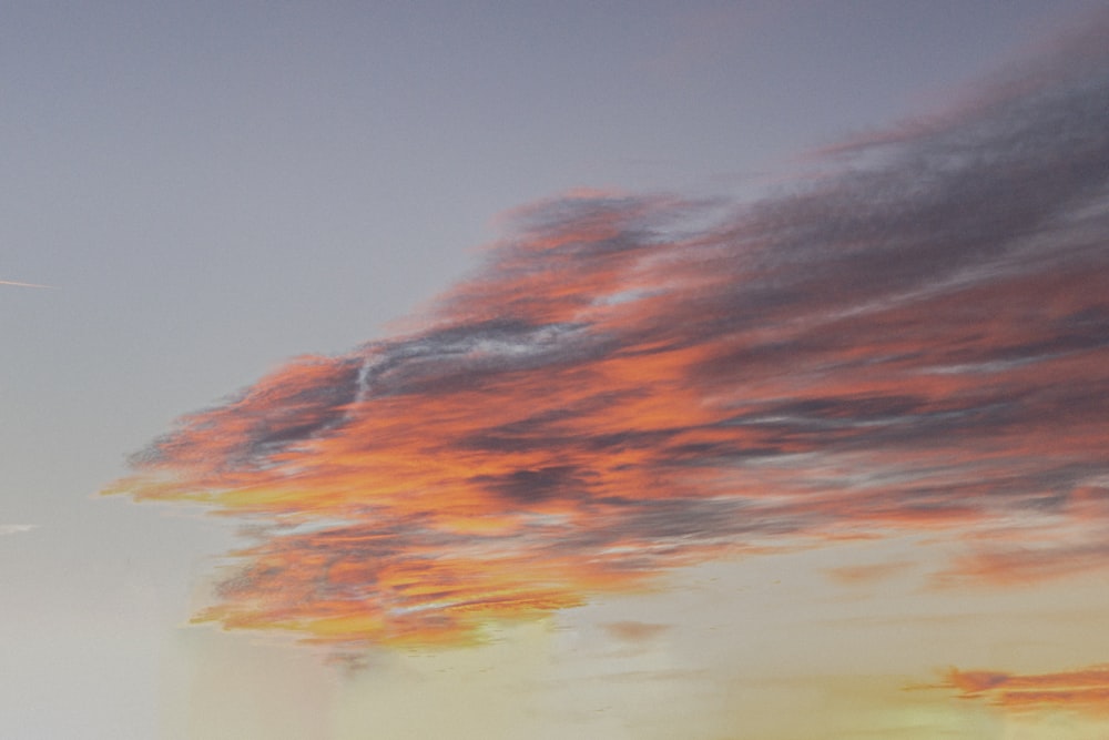 a plane is flying in the sky at sunset