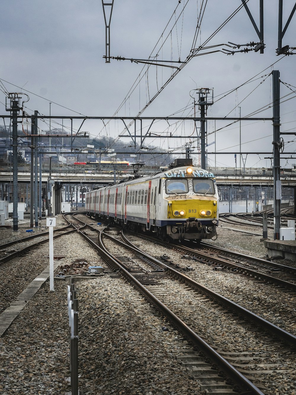 a yellow and white train traveling down train tracks