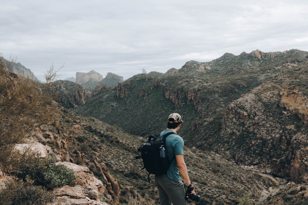 a man with a backpack standing on a mountain