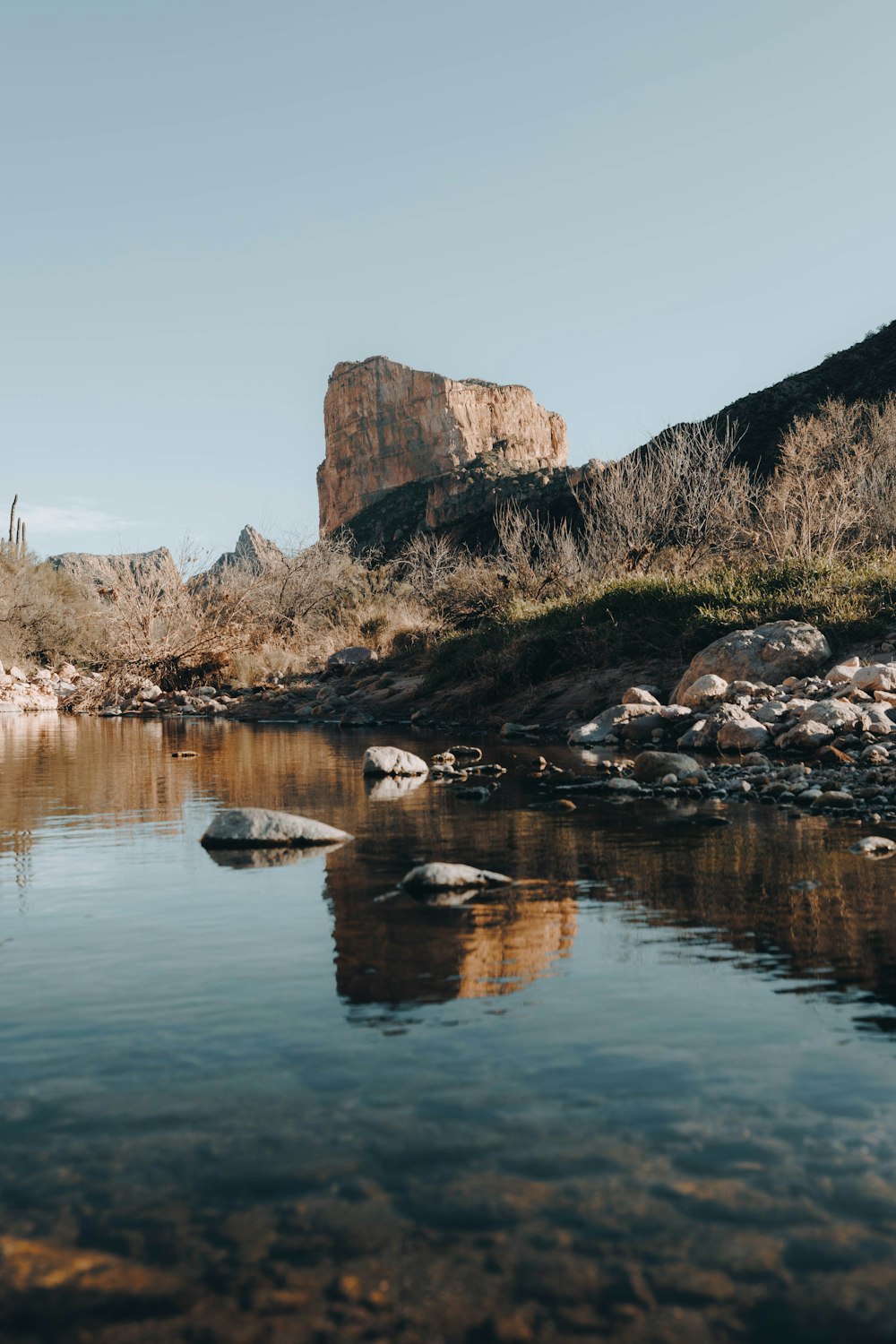 a body of water surrounded by rocks and a mountain