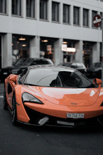 A sleek orange car parked in a modern urban setting, highlighting sophistication.