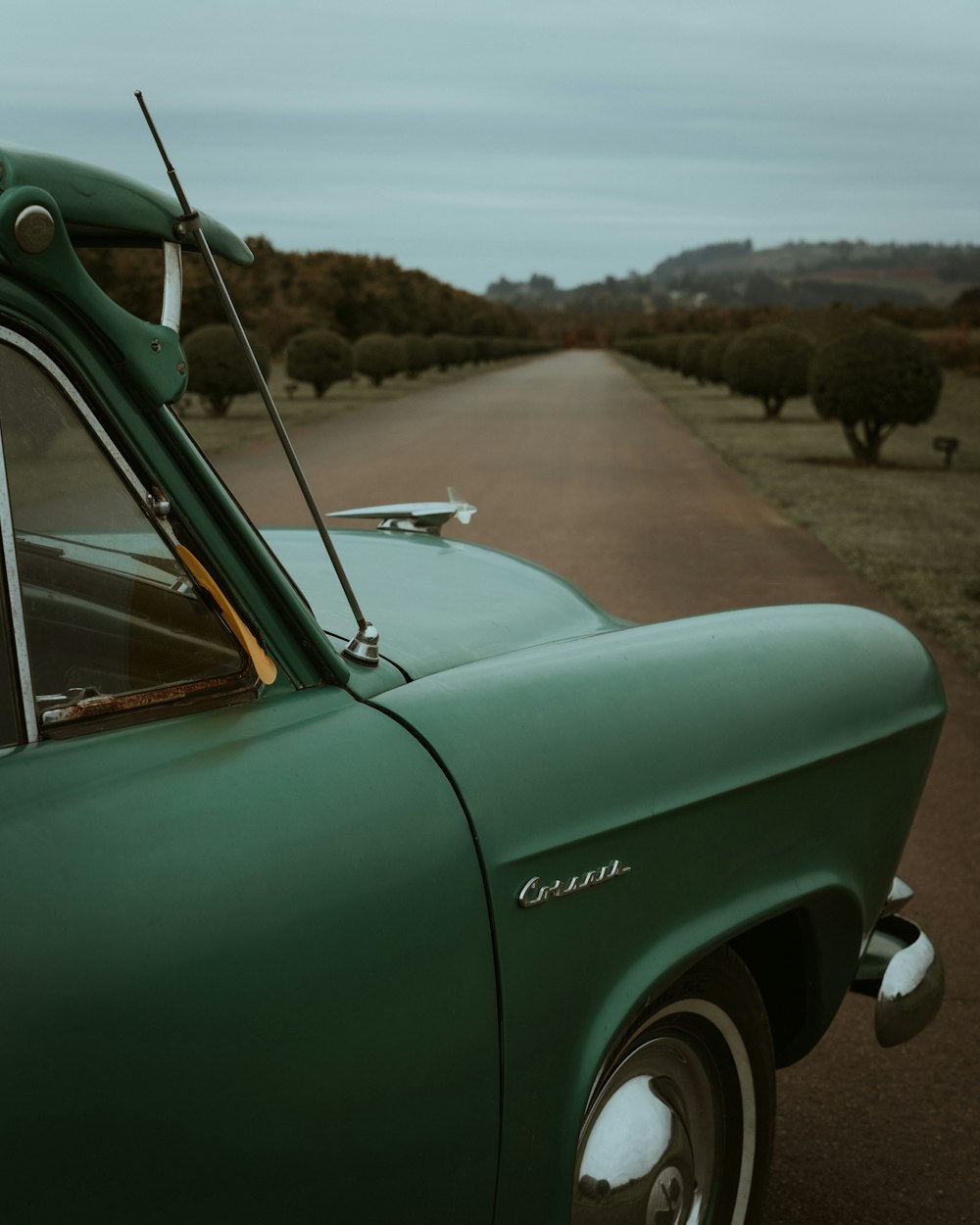 a green car parked on the side of a road