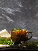 Steam rising from a pot of simmering soup, surrounded by fresh herbs and rustic kitchen tools.