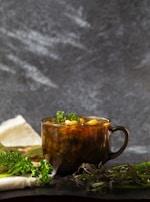A steaming bowl of homemade soup on a rustic kitchen counter.