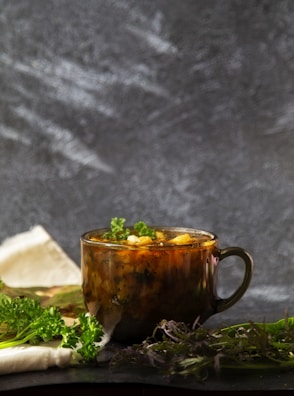 Steam rising from a pot of simmering soup, surrounded by fresh herbs and rustic kitchen tools.