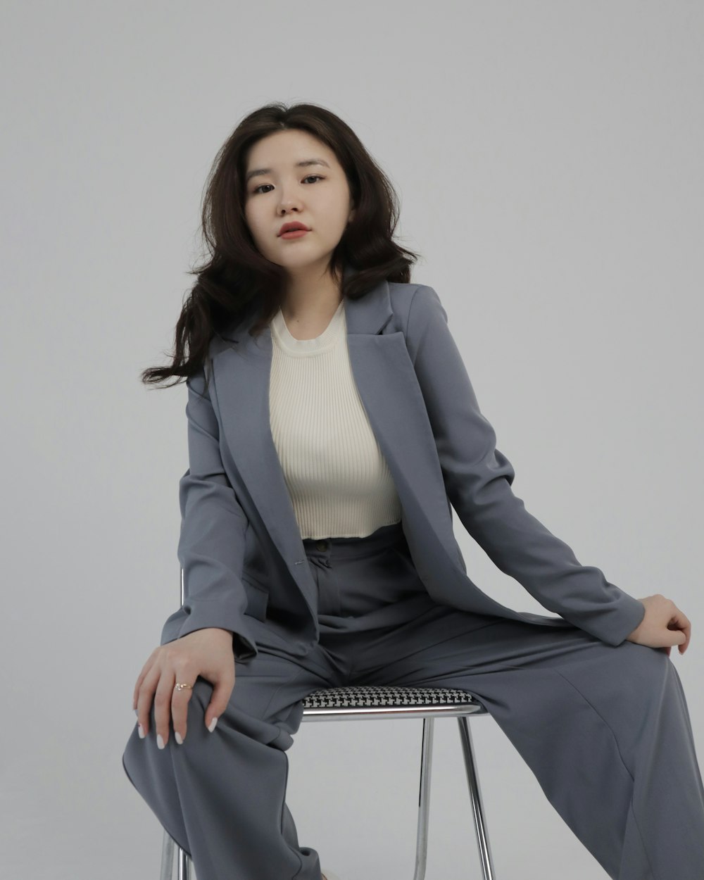 a woman sitting on top of a metal chair