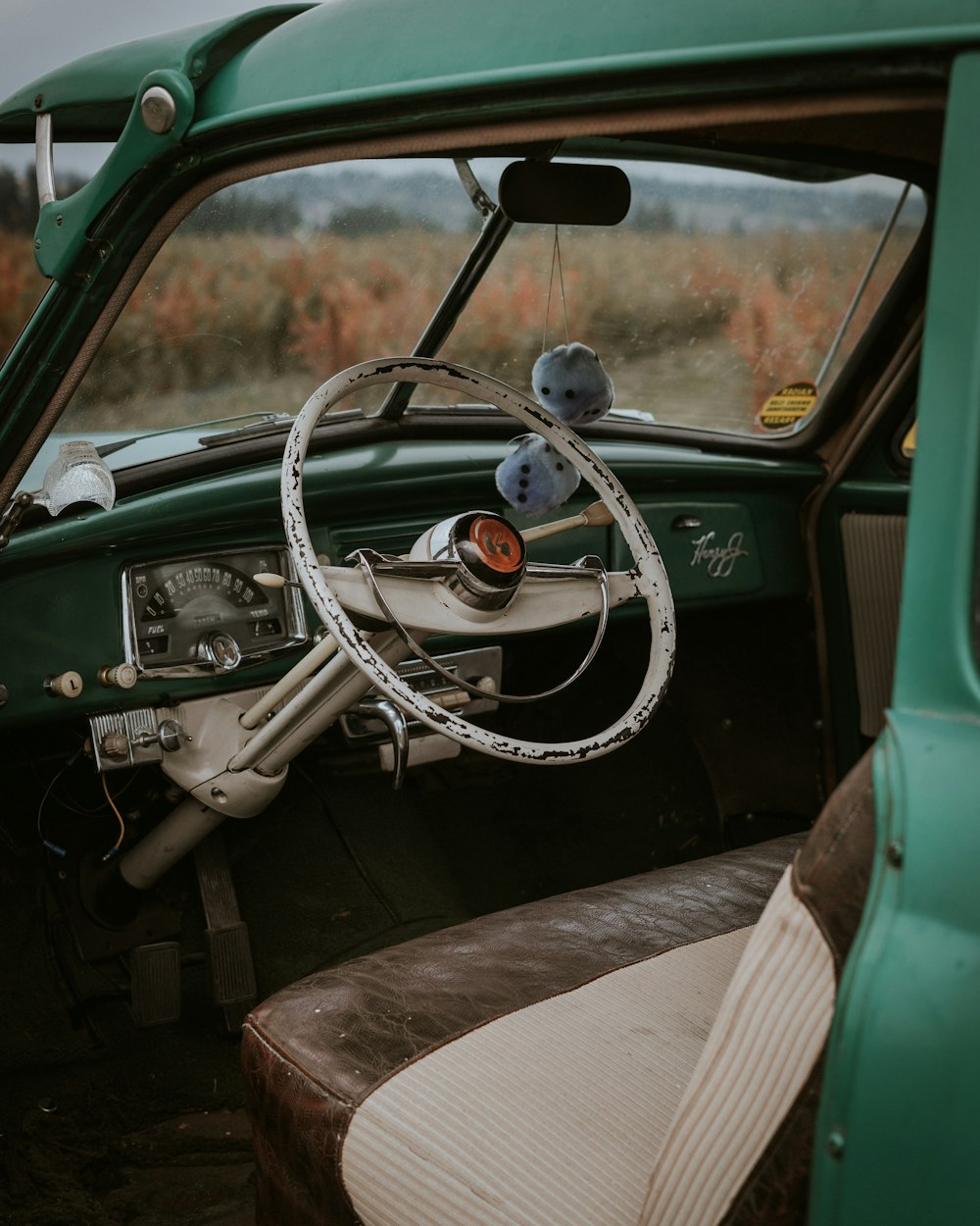 the interior of a green car with a steering wheel