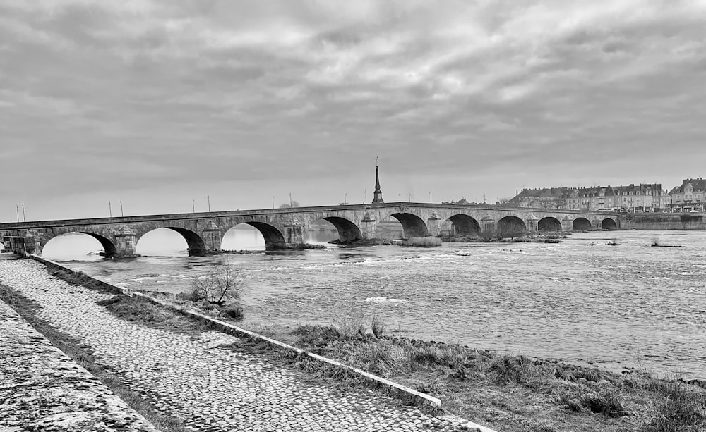 Una foto in bianco e nero di un ponte su un fiume