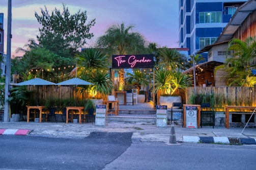 A welcoming restaurant entrance with vibrant plants and signage.