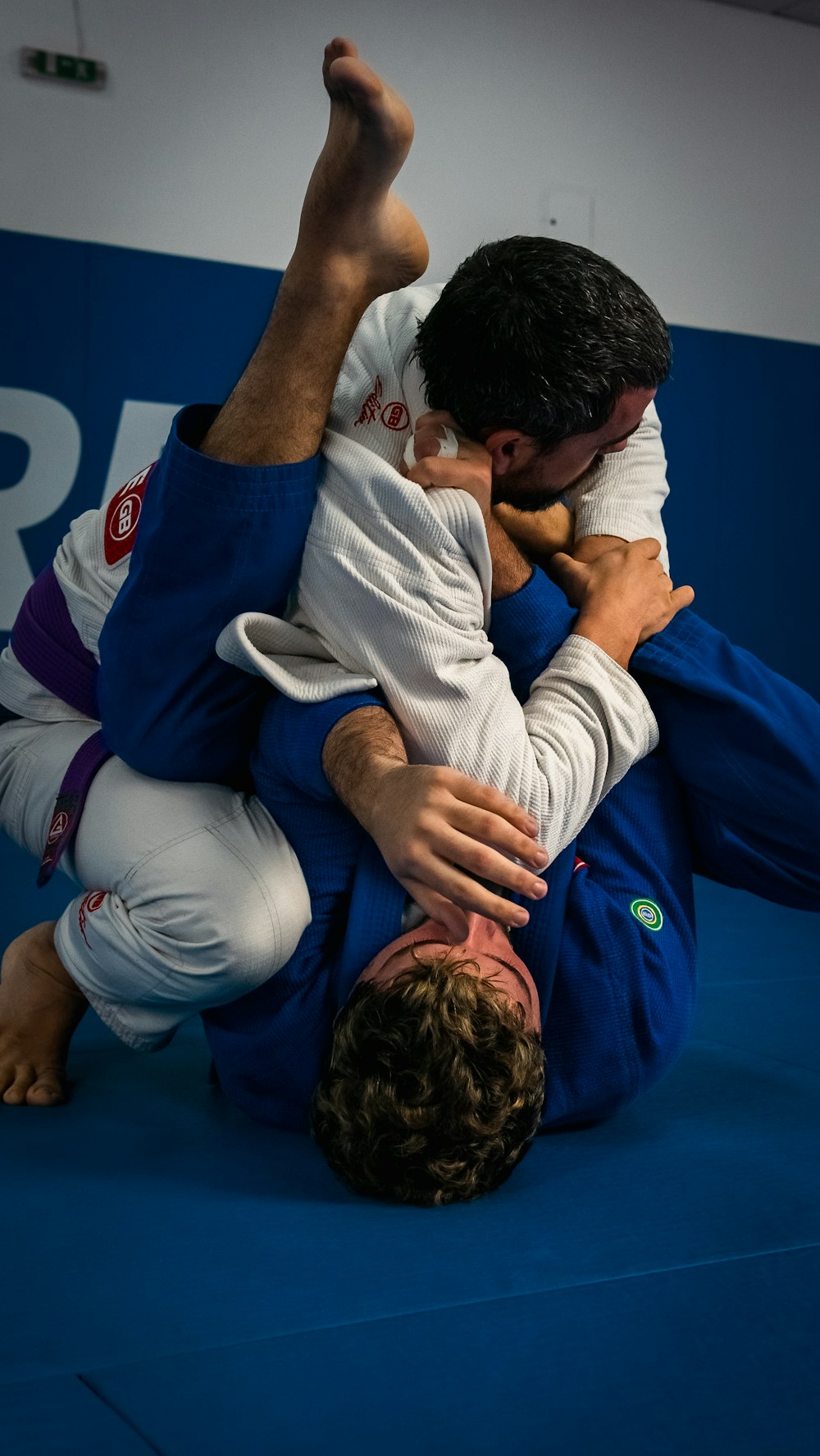 a man in a blue uniform is doing a back kick