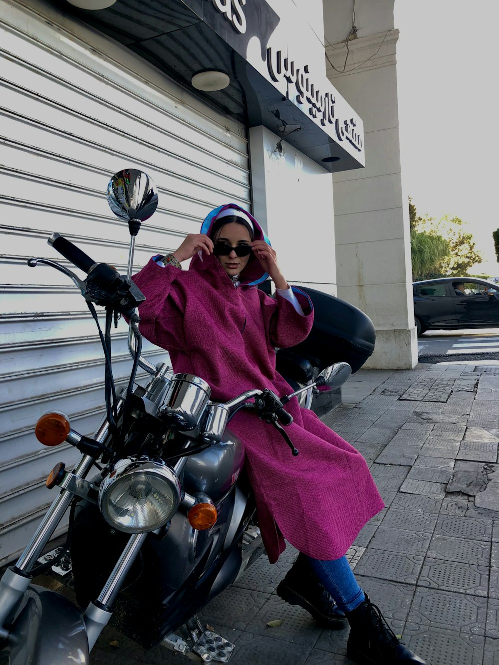 a woman sitting on a motorcycle in front of a building