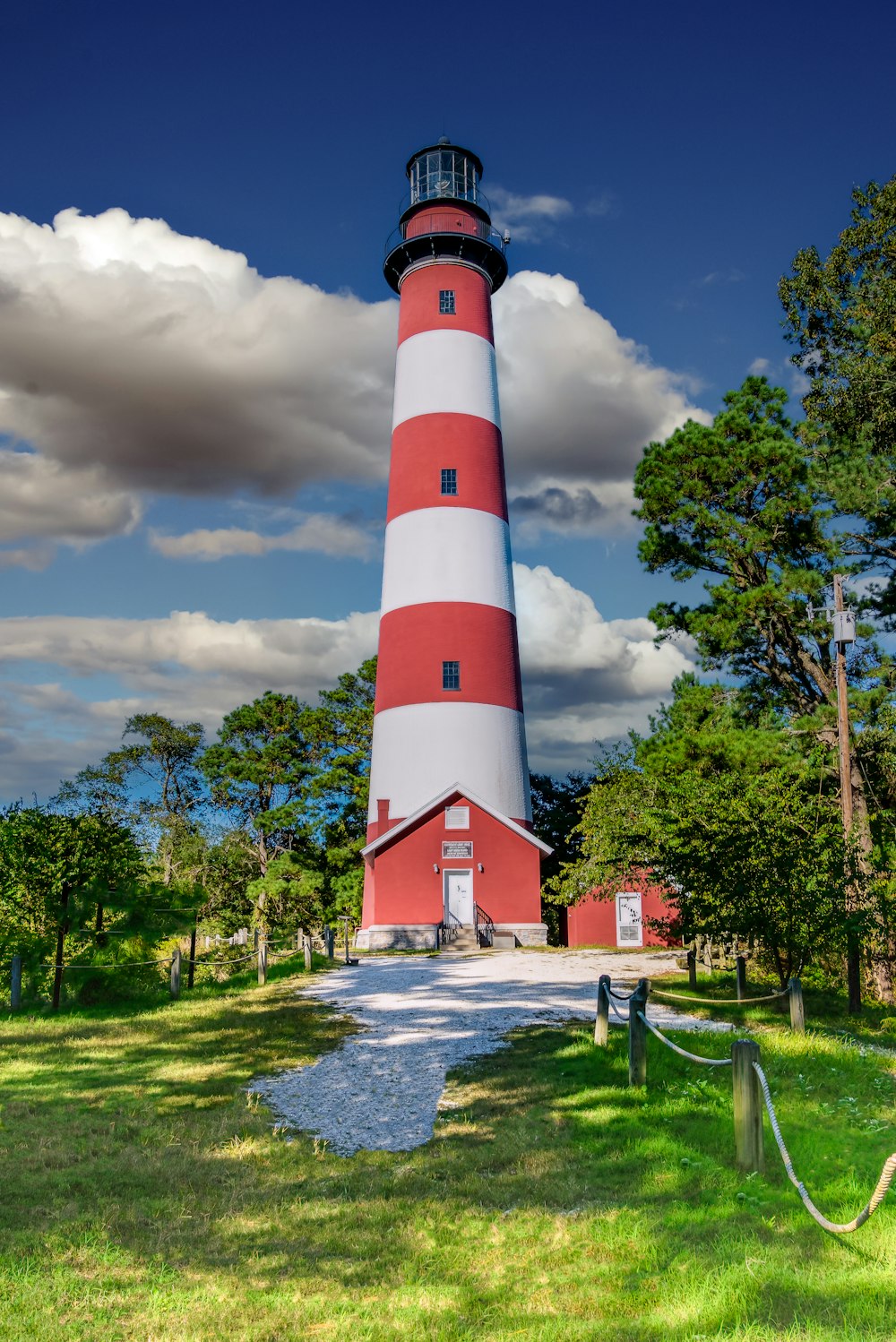 a red and white light house sitting on top of a lush green field