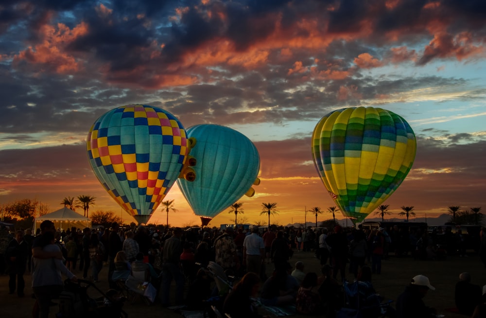 a group of people standing around hot air balloons